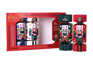 Two green and red nutcracker Christmas cracker tea boxes displayed standing upright next to the opened English Tea Shop gift set.